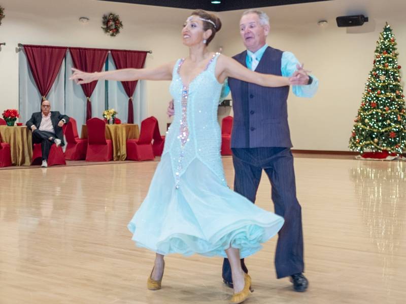 Jeanette dancing with student foxtrot at Holiday Showcase